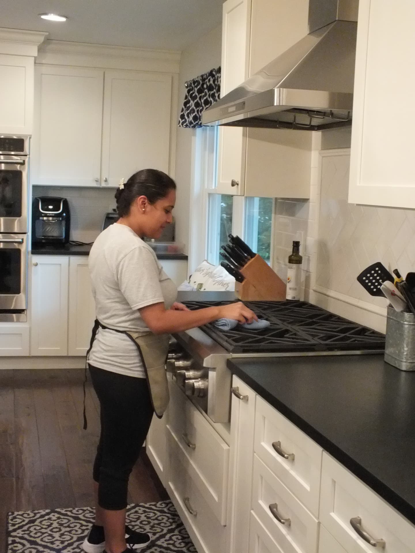 M & M Brothers team member wiping down a kitchen stovetop