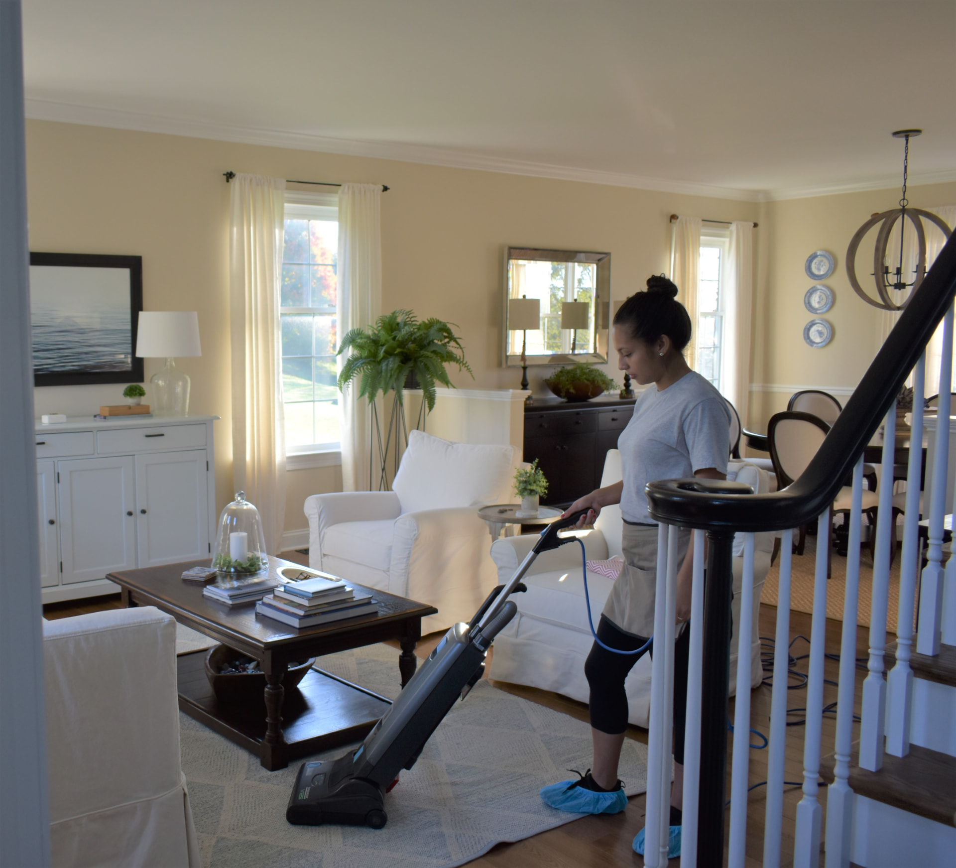 M & M Brothers team member vacuuming a family living room